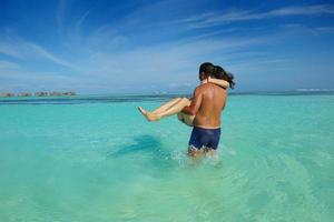 asian couple enjoying summer on beach photo