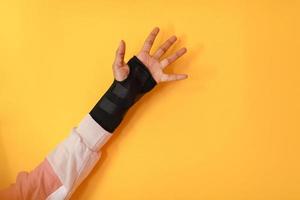 hand injury. a female injured hand on a yellow background photo