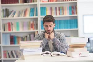 portrait of student while reading book  in school library photo