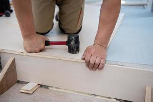 Professional Worker Installing New Laminated Wooden Floor photo