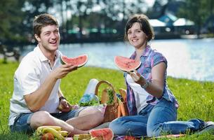 feliz pareja joven haciendo un picnic al aire libre foto