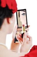 beautiful young woman applying makeup photo