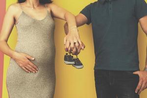 couple holding newborn baby shoes photo