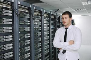 young engeneer in datacenter server room photo