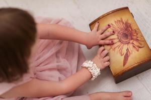 niña disfrutando mientras juega con las joyas de la madre foto