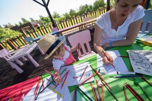 mamá y su pequeña hija dibujando imágenes coloridas foto