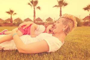 mother and little daughter playing at backyard photo