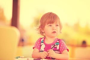 niña dibujando imágenes coloridas foto