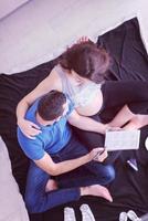 vista superior de una pareja revisando una lista de cosas para su bebé por nacer foto
