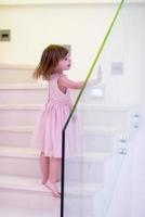 little girl playing on stairs at home photo