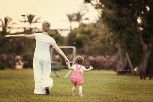 mother and little daughter playing at backyard photo