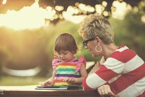 mom and her little daughter using tablet computer photo