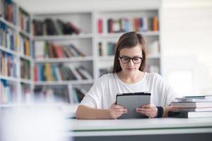 female student study in school library, using tablet photo