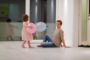 mother and cute little daughter playing with balloons photo