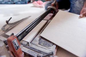 worker cutting the ceramic wood effect tiles photo