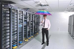 businessman hold umbrella in server room photo