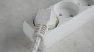 the man inserts a plug from the outlet of an electric extension cord, close up. video