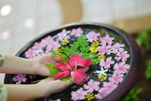 mano femenina y flor en agua foto