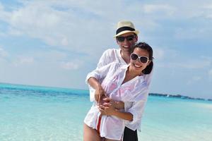 feliz pareja joven divertirse en la playa foto