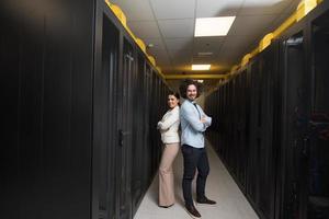 engineer showing working data center server room to female chief photo