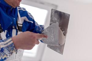 construction worker plastering on gypsum walls photo