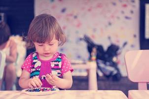 little girl drawing a colorful pictures photo