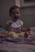 cute  little one year old baby and making first steps in bed photo