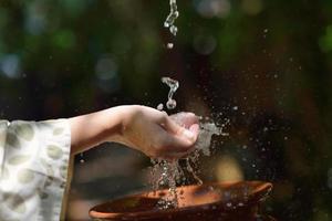 salpicando agua dulce en manos de mujer foto