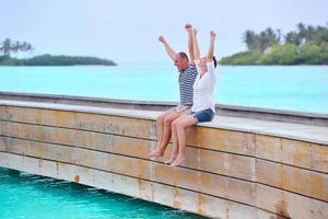 feliz pareja joven divertirse en la playa foto