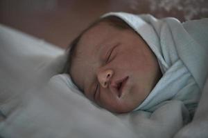 bebé recién nacido durmiendo en la cama en el hospital foto