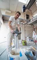 construction worker mixing plaster in bucket photo