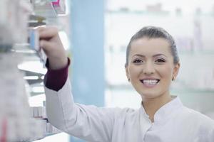 Farmacéutico químico mujer de pie en farmacia droguería foto