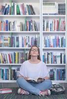 famale student reading book in library photo