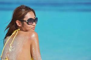 asian woman resting on sand at beach photo