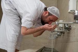 A Muslim takes ablution for prayer. Islamic religious rite photo