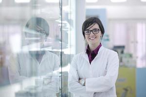 pharmacist chemist woman standing in pharmacy drugstore photo