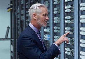 Senior businessman in server room photo