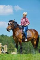 mujer feliz montar a caballo foto