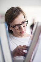 portrait of famale student selecting book to read in library photo