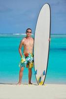 Man with surf board on beach photo