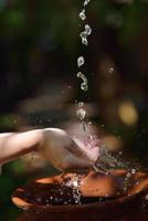 salpicando agua dulce en manos de mujer foto