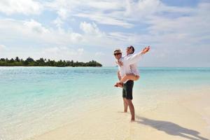 feliz pareja joven divertirse en la playa foto