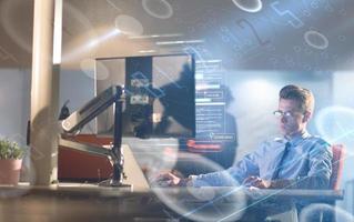 hombre trabajando en una computadora en una oficina oscura foto