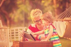 mom and her little daughter using tablet computer photo