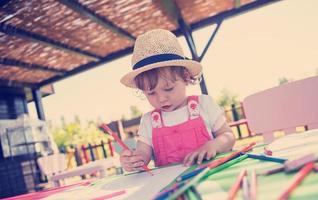 niña dibujando imágenes coloridas foto