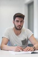 male student taking notes in classroom photo