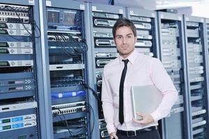 businessman with laptop in network server room photo