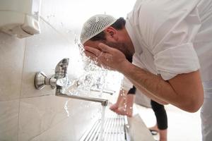 a group of Muslims take ablution for prayer. Islamic religious rite photo