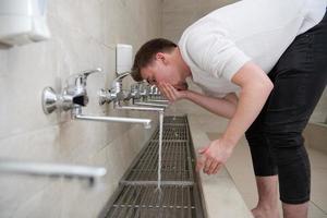 A Muslim takes ablution for prayer. Islamic religious rite photo