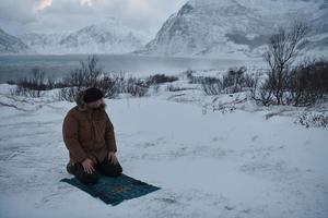 viajero musulmán rezando en el frío día de invierno nevado